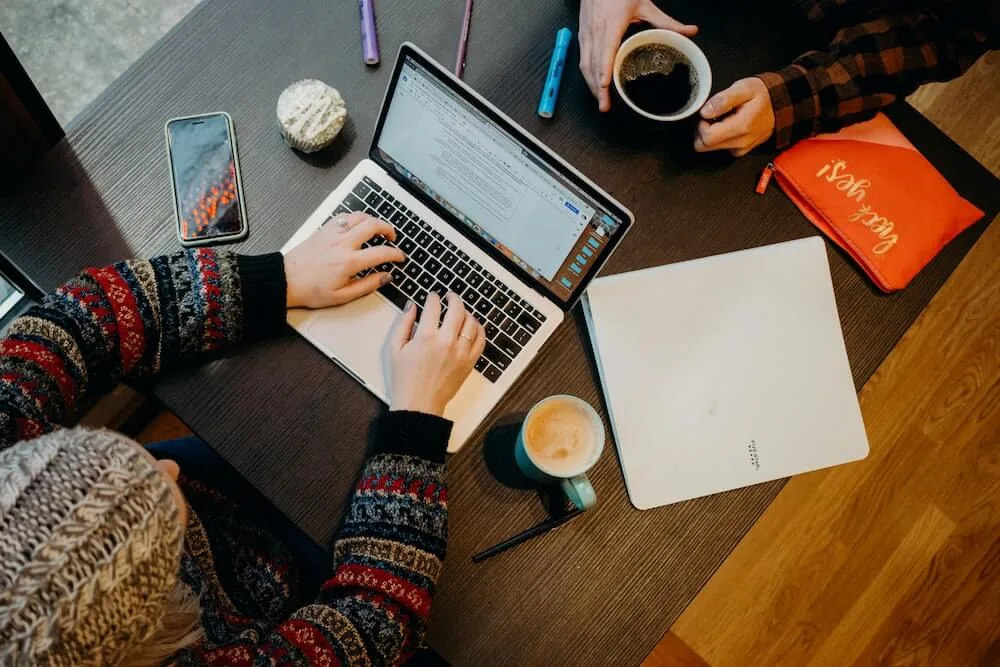 Persona escribiendo en un cuaderno con un bolígrafo, simbolizando el aprendizaje.